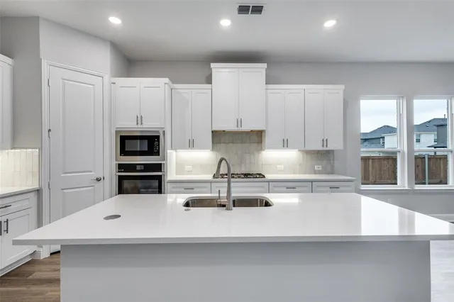 a kitchen with kitchen island a white counter top and appliances