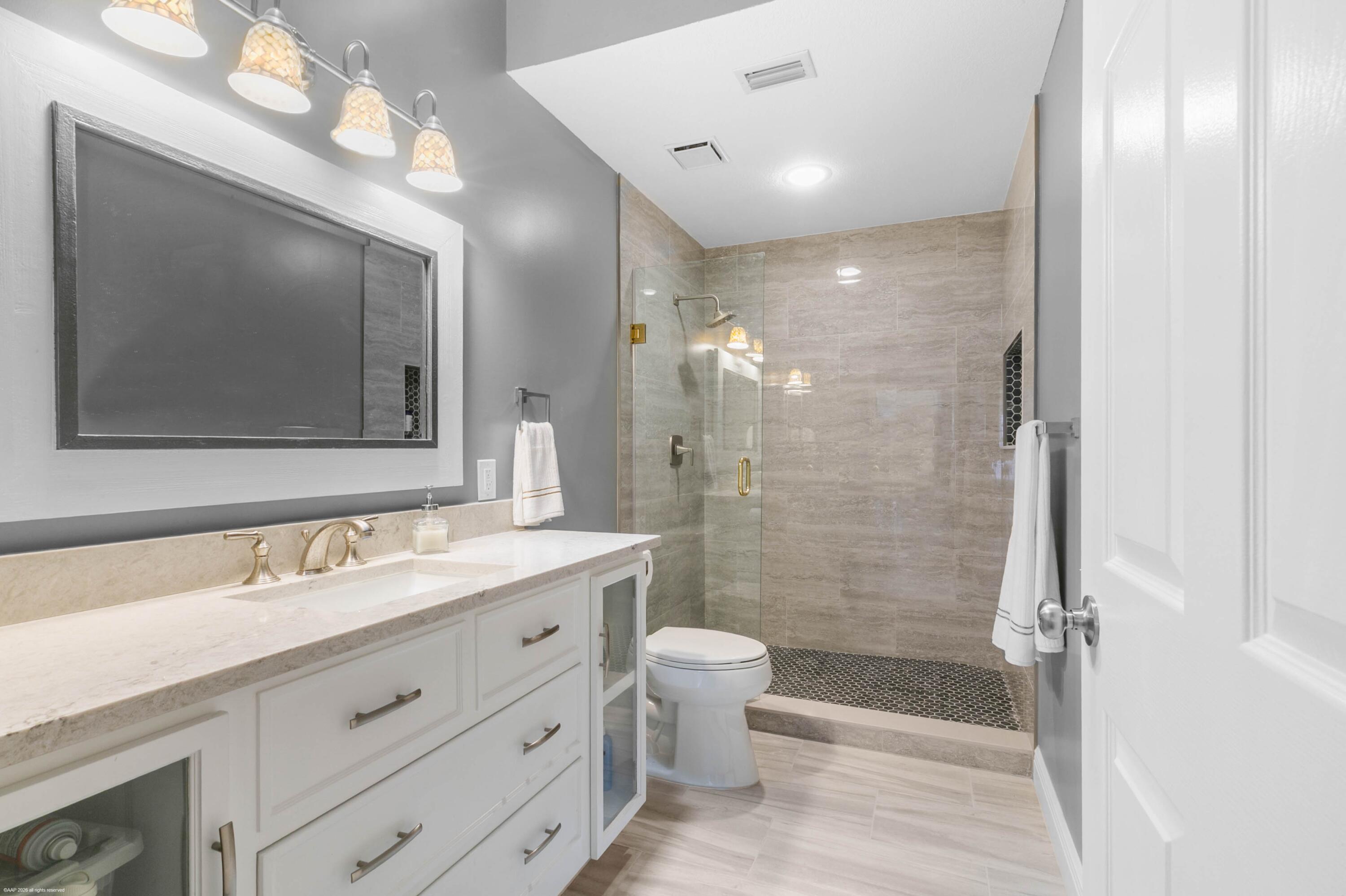 12635 Timber Ridge Circle Wellington, FL 33414 - Photo 20 of 33 a bathroom with a double vanity sink mirror double shower and a toilet