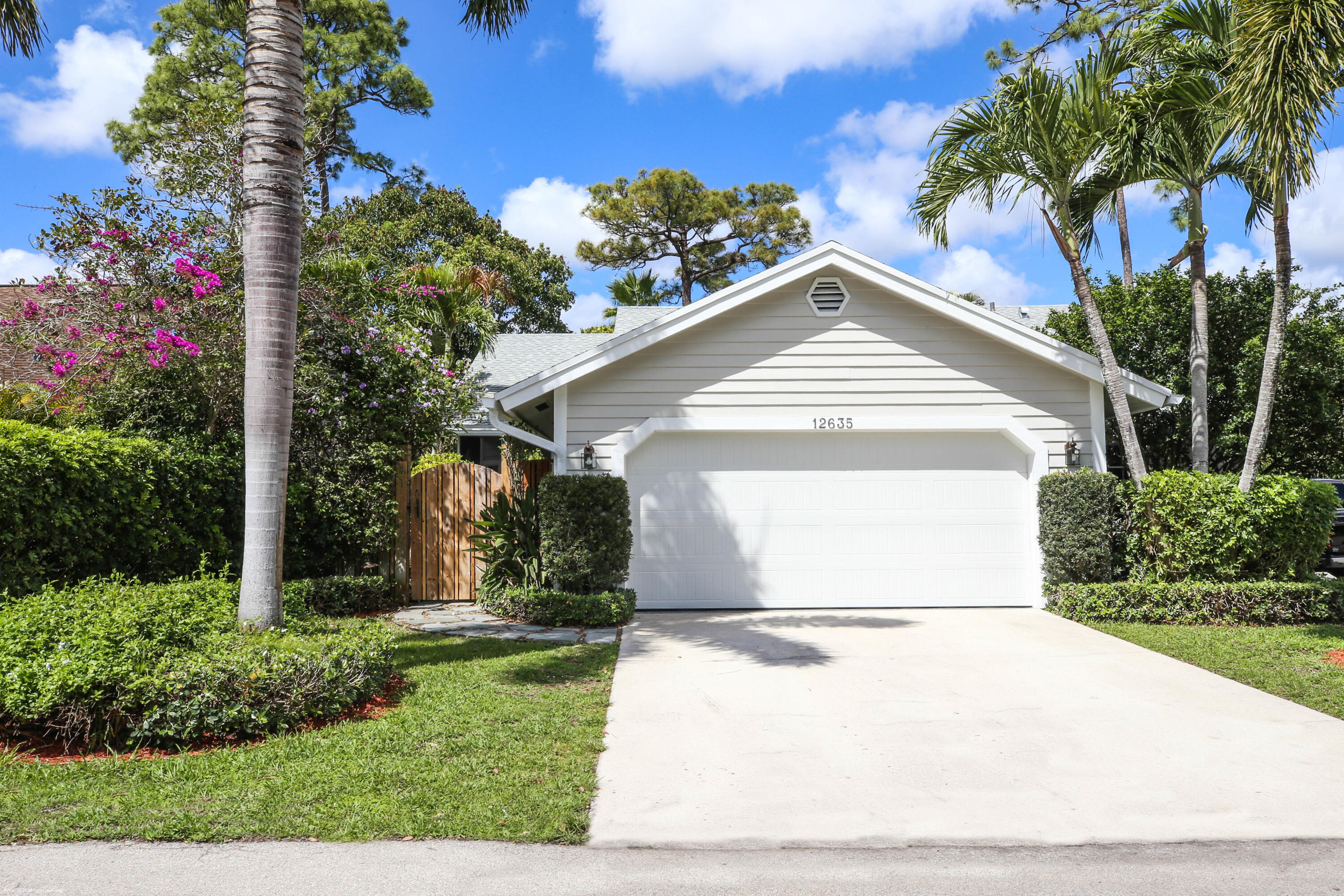 12635 Timber Ridge Circle Wellington, FL 33414 - Photo 2 of 33 a front view of a house with a yard and garage