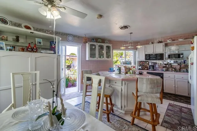 a living room with furniture a chandelier and kitchen view