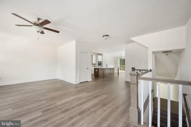 a view of a hallway with wooden floor and entryway