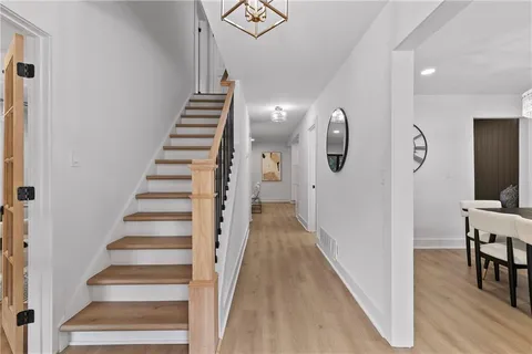 a view of entryway and hall with wooden floor