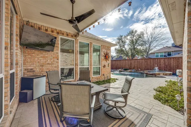 a view of a patio with a table chairs and a barbeque