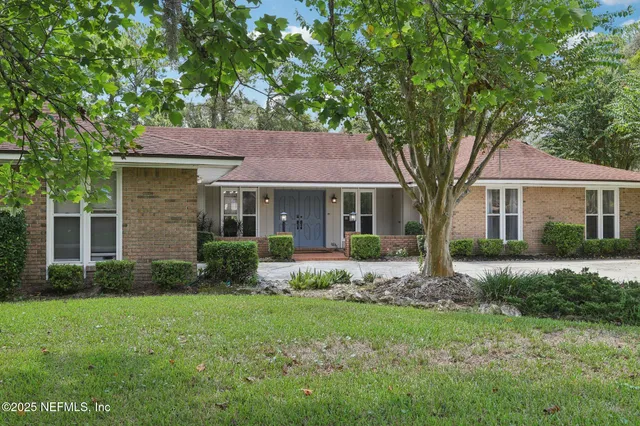 a dining room with wooden floor a chandelier a wooden table and chairs