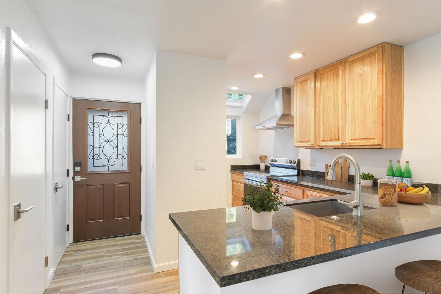 8667 Mariners Drive, Unit 53 Stockton, CA 95219 - Photo 4 of 24 a kitchen with kitchen island granite countertop a sink and dishwasher with wooden cabinets