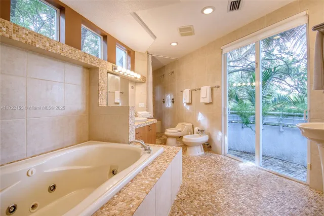 a bathroom with a tub a sink and a mirror