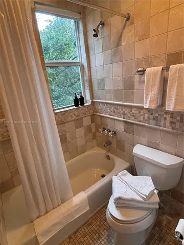 a bedroom with a bed lamp on table and a window