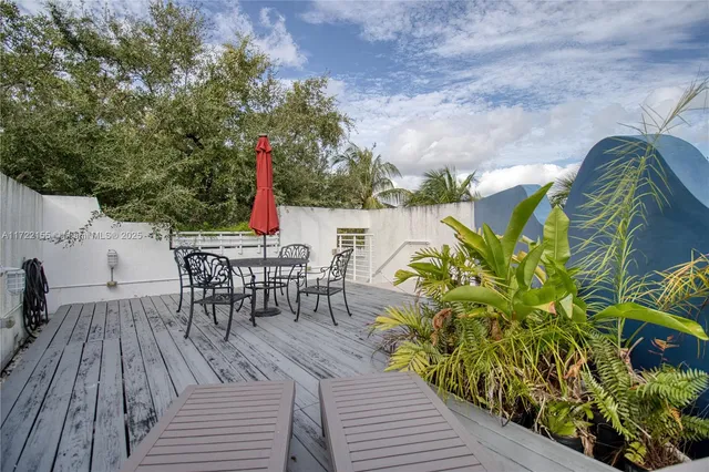 a view of a patio with table and chairs with wooden fence and plants