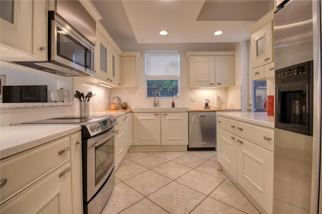 a kitchen with stainless steel appliances granite countertop a sink and dishwasher a stove top oven with white cabinets