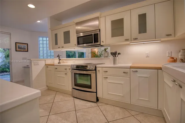 a living room with furniture a flat screen tv and a chandelier