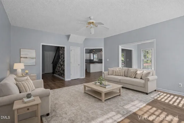 a living room with furniture and view of kitchen