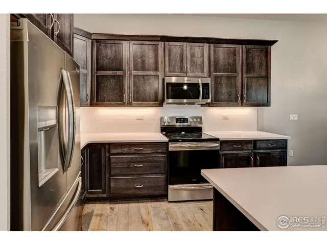 a kitchen with kitchen island a counter top a stove and a refrigerator