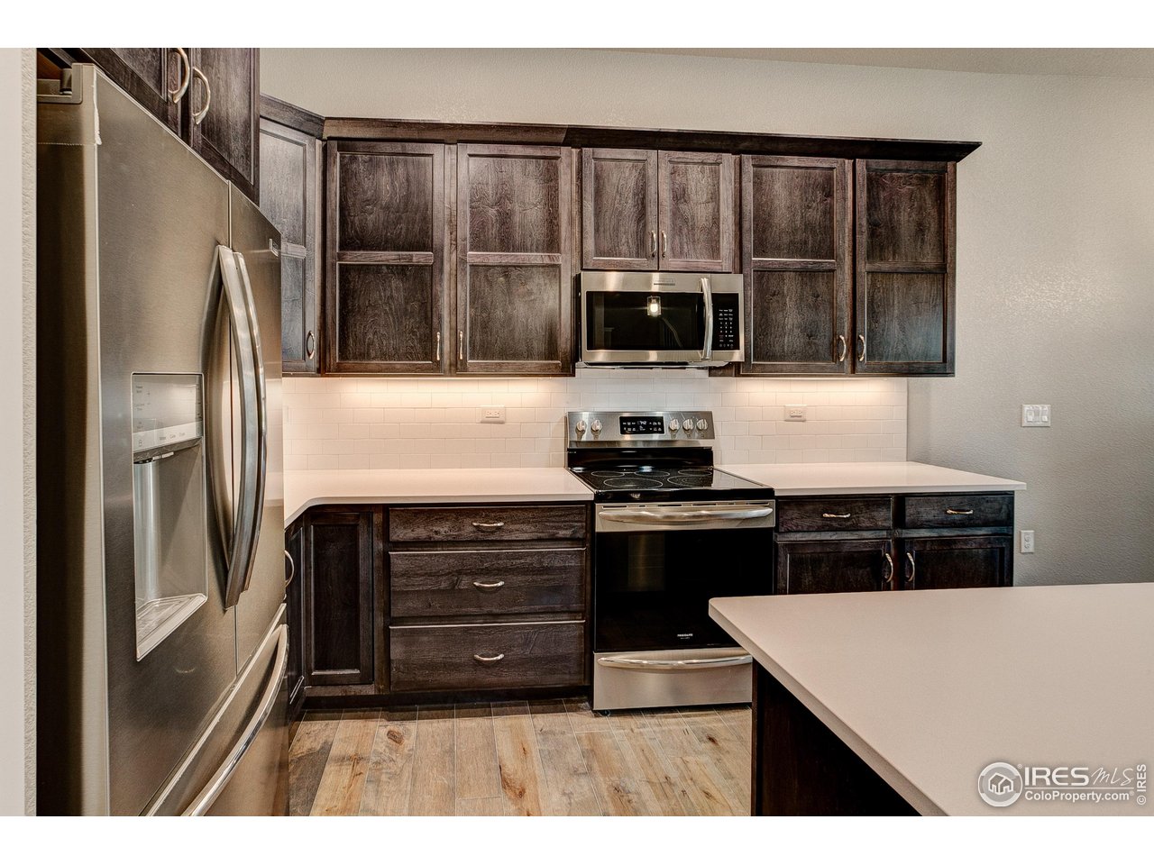 6227 Vernazza Way, Unit 2 Windsor, CO 80550 - Photo 6 of 35 a kitchen with kitchen island a counter top a stove and a refrigerator