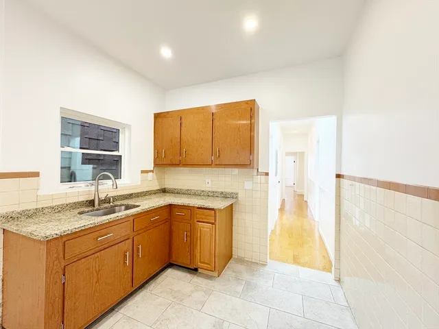 a kitchen with a sink a stove top oven and cabinetry