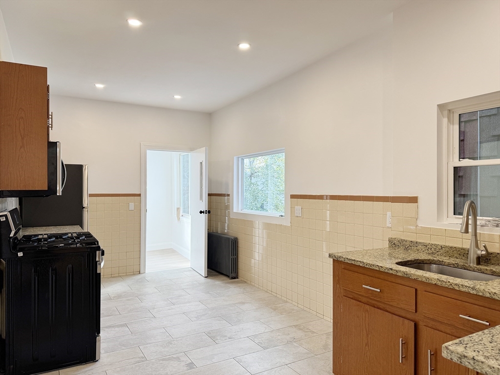71 West Eagle Street, Unit 2 Boston, MA 02128 - Photo 12 of 31 a kitchen with a refrigerator and a stove top oven
