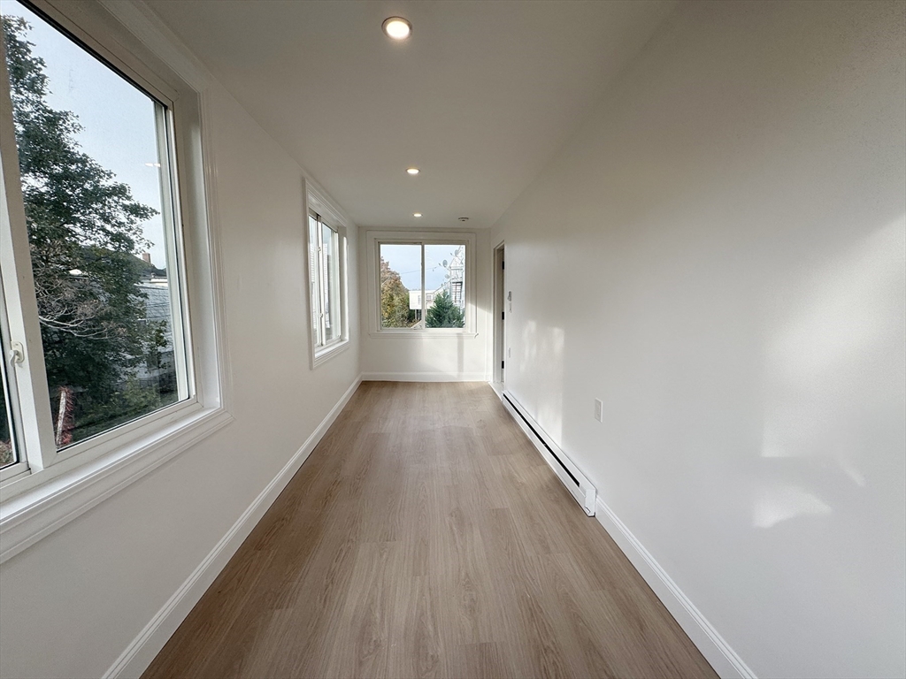 71 West Eagle Street, Unit 2 Boston, MA 02128 - Photo 14 of 31 a view of a big room with wooden floor and windows