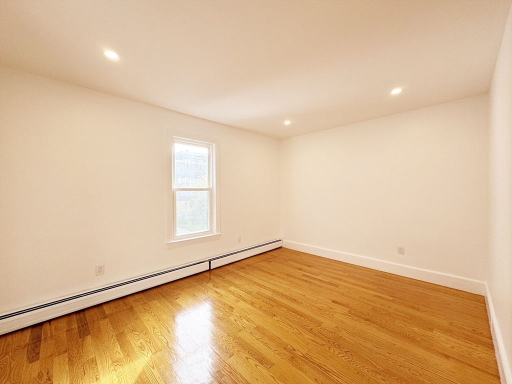 71 West Eagle Street, Unit 2 Boston, MA 02128 - Photo 16 of 31 an empty room with wooden floor and windows