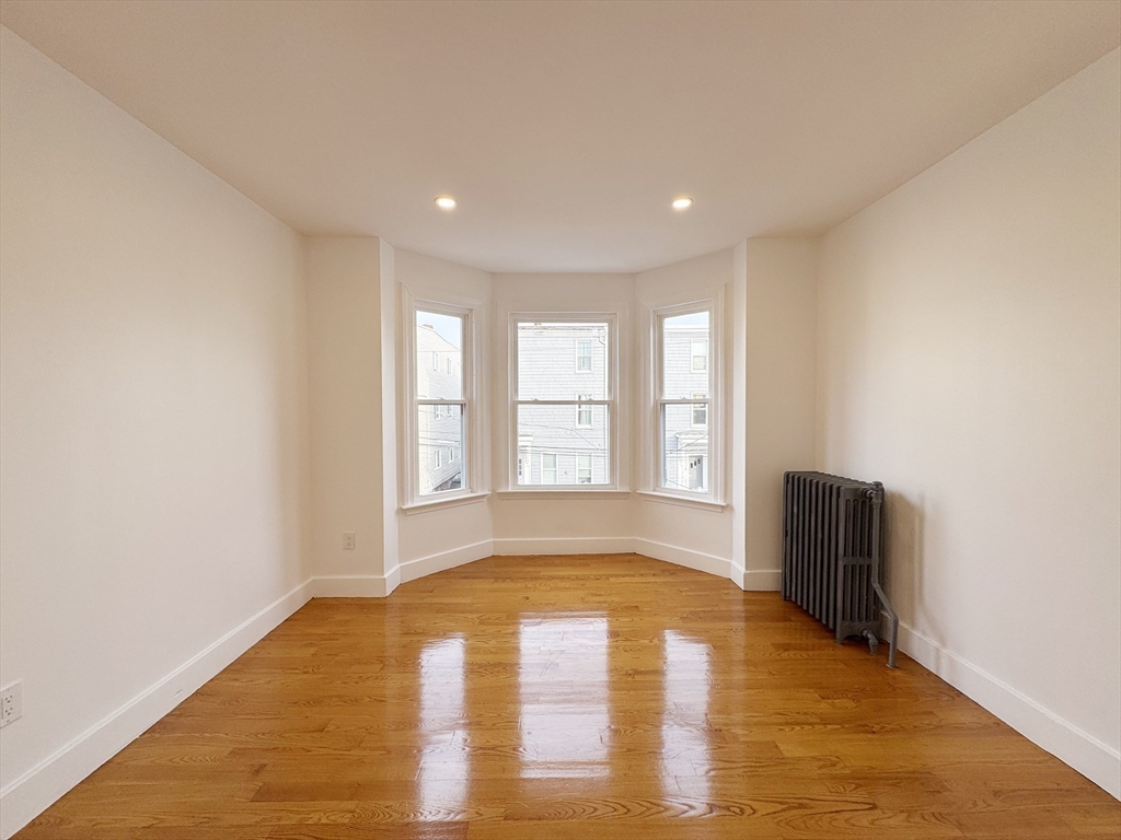 71 West Eagle Street, Unit 2 Boston, MA 02128 - Photo 3 of 31 a view of an empty room with wooden floor and a window