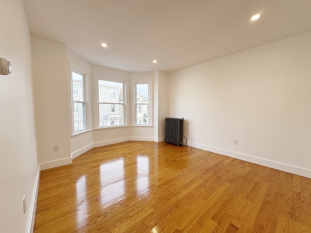71 West Eagle Street, Unit 2 Boston, MA 02128 - Photo 5 of 31 a view of an empty room with a window and wooden floor