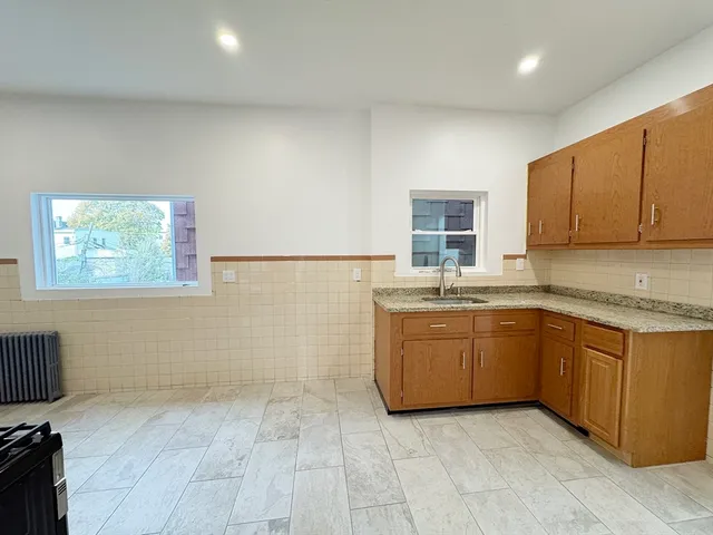 a kitchen with granite countertop a sink a stove top oven and a granite counter tops