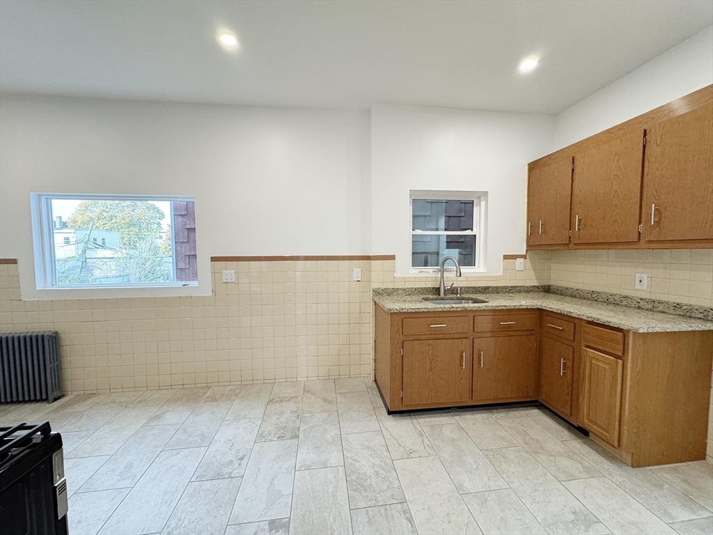 71 West Eagle Street, Unit 2 Boston, MA 02128 - Photo 10 of 31 a kitchen with granite countertop a sink a stove top oven and a granite counter tops