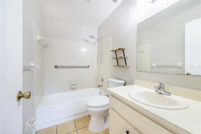 a bathroom with a toilet a sink a mirror a bathtub and shower