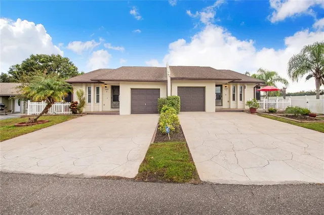 a view of a white house with a yard and potted plants
