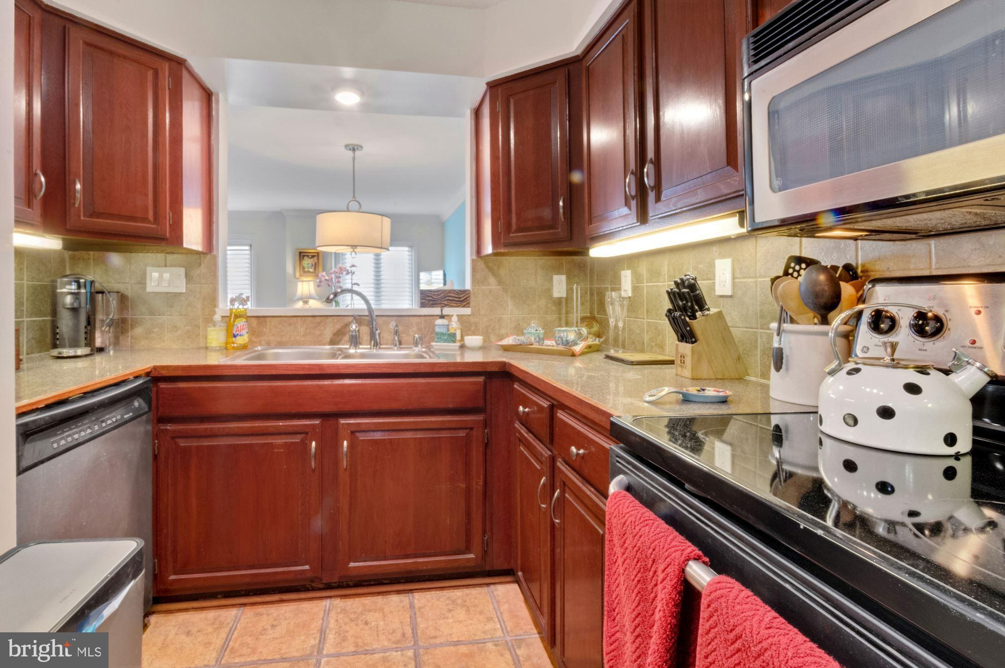 1080 Wisconsin Avenue Northwest, Unit 405 Washington, DC 20007 - Photo 15 of 31 a kitchen with stainless steel appliances granite countertop a sink stove and cabinets