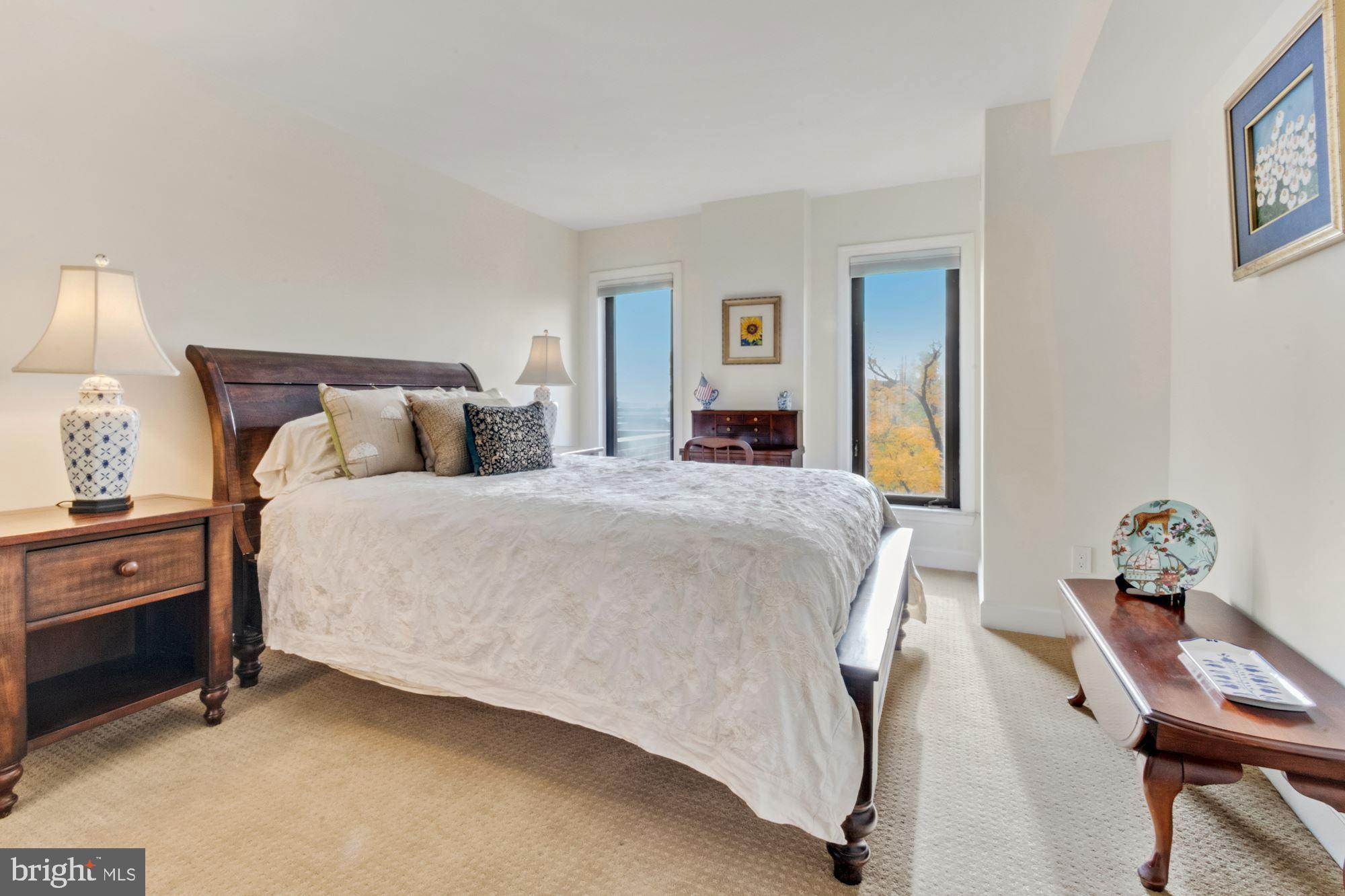 1080 Wisconsin Avenue Northwest, Unit 405 Washington, DC 20007 - Photo 20 of 31 a bed room with a bed and a lamp