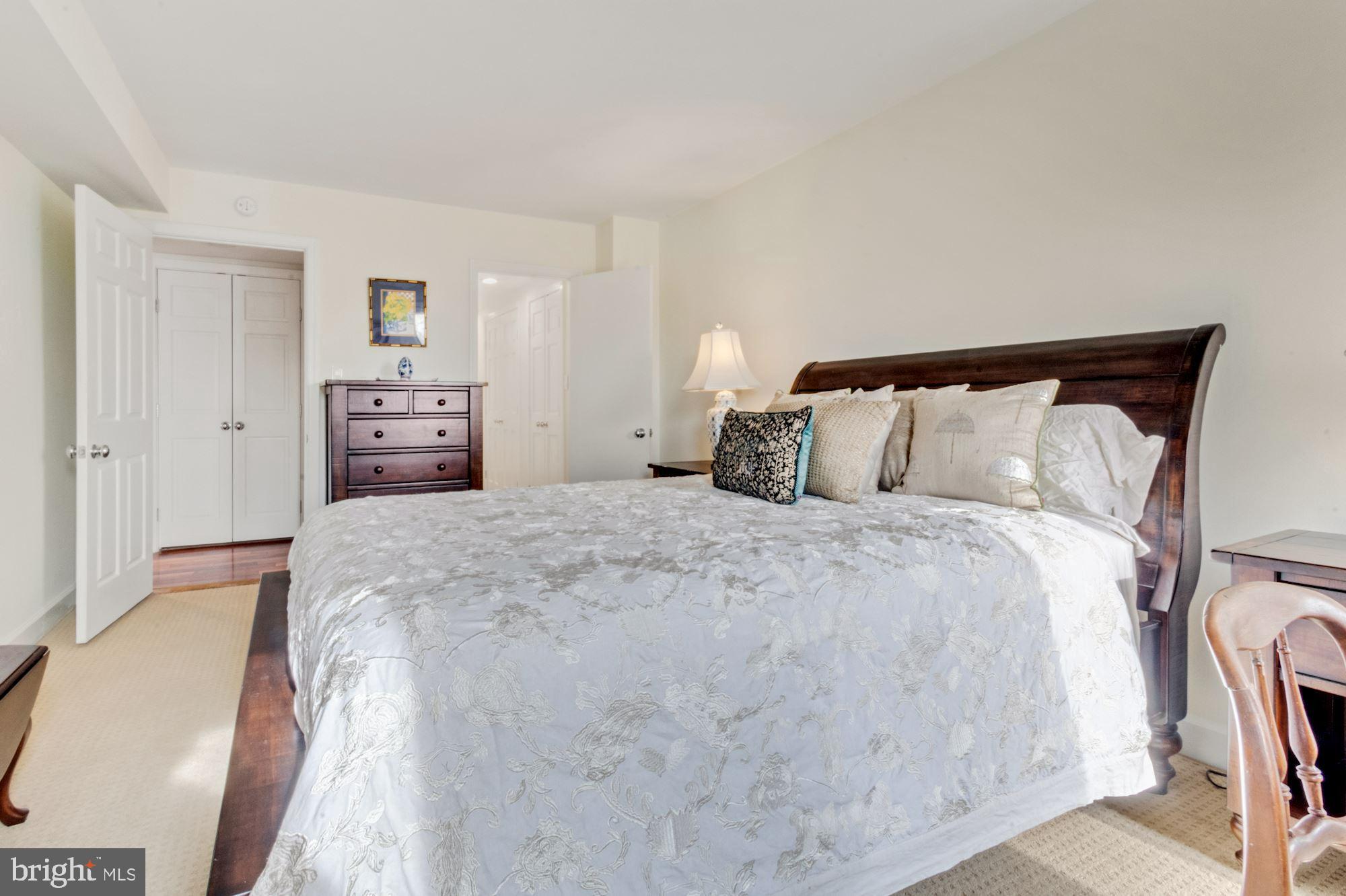 1080 Wisconsin Avenue Northwest, Unit 405 Washington, DC 20007 - Photo 21 of 31 a bedroom with a bed and a lamp