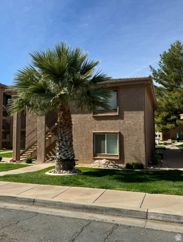 View of side of home with stucco siding and a lawn