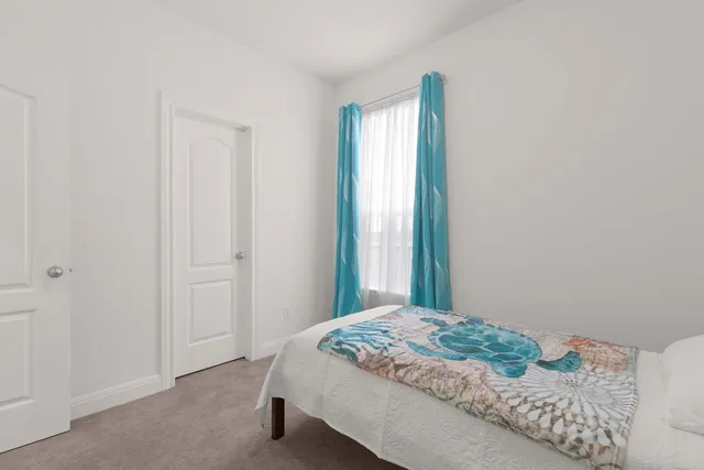 a bed sitting in a bedroom next to a window