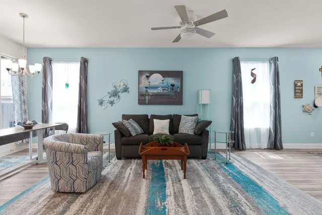 a living room with furniture and a wooden floor