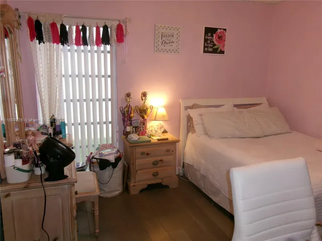 a bedroom with a bed and a potted plant
