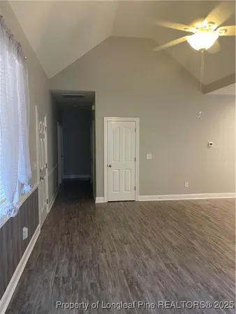 a view of an empty room with window and wooden floor