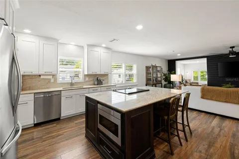 a large kitchen with stainless steel appliances granite countertop a lot of counter space and a sink