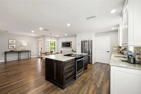 a view of a kitchen with a sink refrigerator and wooden floor