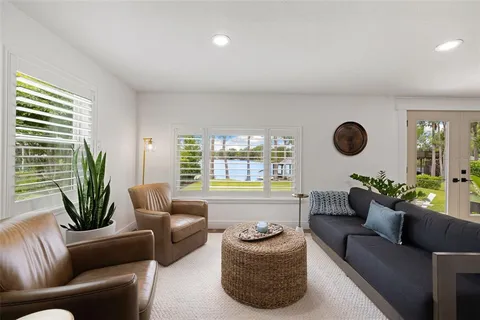 a view of house with a big yard potted plants and large tree
