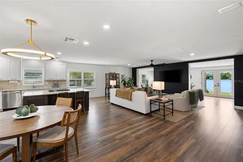 a kitchen with a dining table chairs and white cabinets
