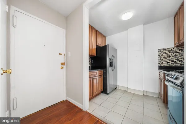 a kitchen with a refrigerator and a stove top oven