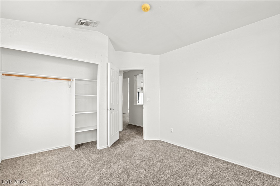 1815 Stablegate Avenue Henderson, NV 89012 - Photo 12 of 28 A well-lit bedroom features plush carpeting and a convenient walk-in closet.
