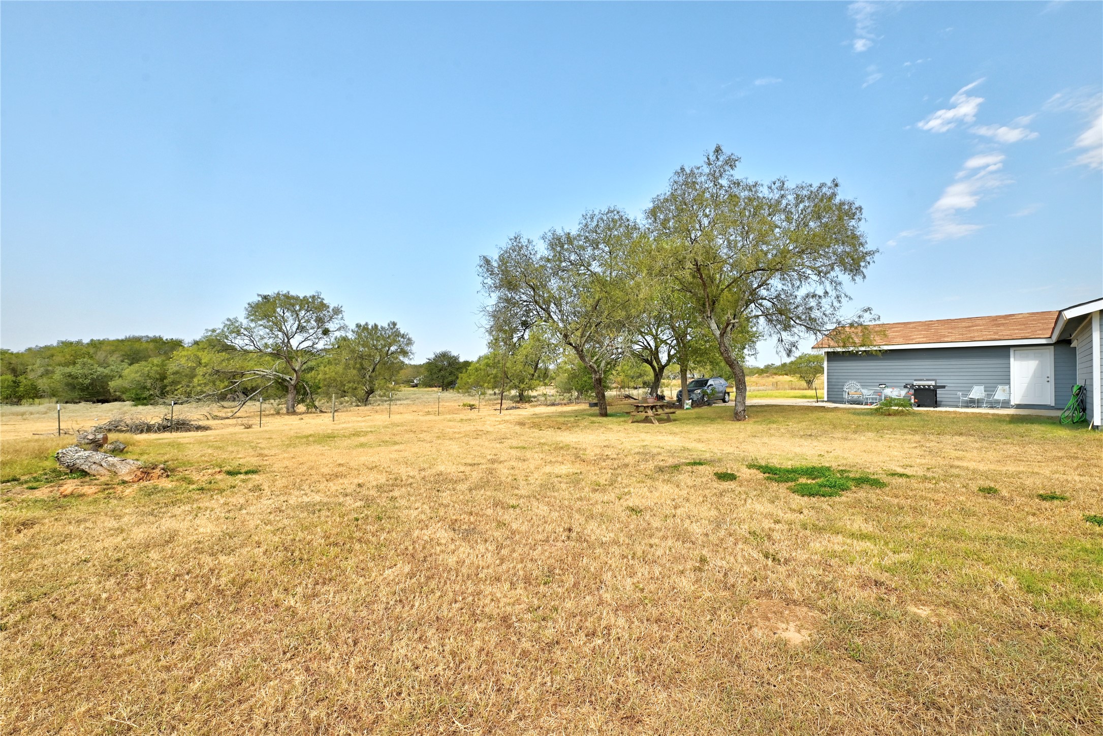 311 Salt Lake Road Luling, TX 78648 - Photo 22 of 37 Mature trees and a sprawling grassy lawn frame the side of the home.