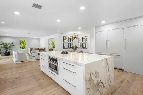 a kitchen with kitchen island a counter top space a sink stainless steel appliances and cabinets