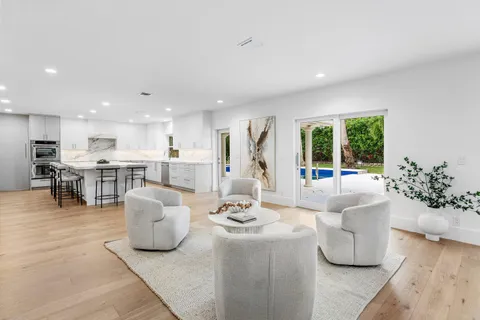 a dining room with couches chairs and kitchen view