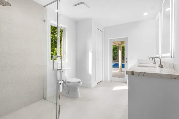 a spacious bathroom with a granite countertop sink a toilet and a shower