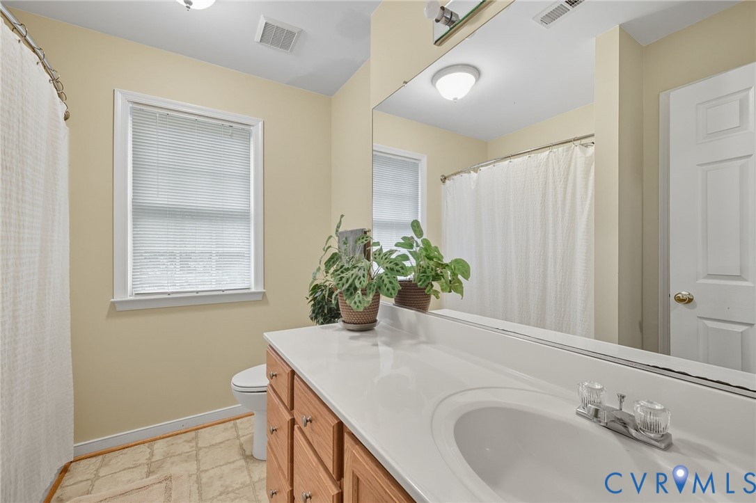3420 Osborne Road Chester, VA 23831 - Photo 26 of 36 a bathroom with a granite countertop sink a mirror and a bathtub