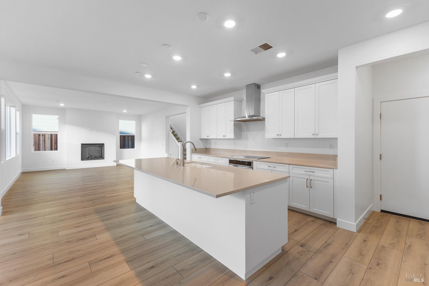 7337 Willowglen Drive Rohnert Park, CA 94928 - Photo 11 of 31 a large white kitchen with kitchen island a sink dishwasher stove and white cabinets with wooden floor