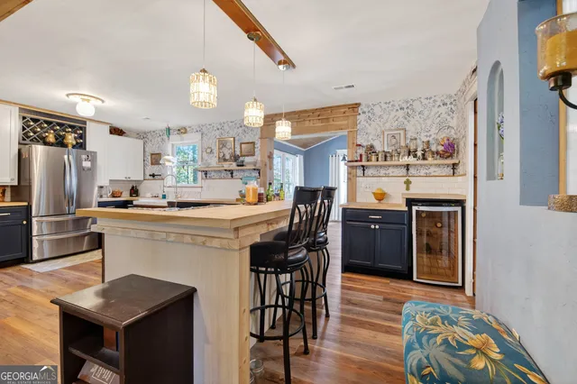 a kitchen with a table chairs refrigerator and cabinets