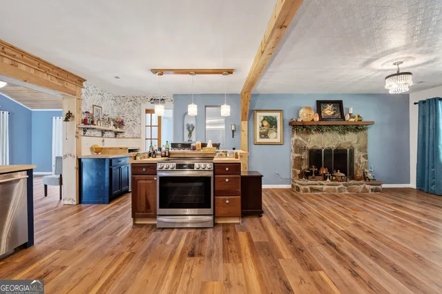 a large kitchen with stainless steel appliances granite countertop a stove and a wooden floors