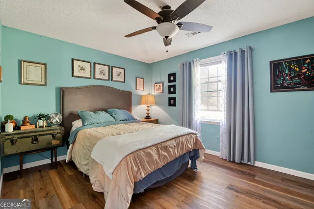 a bedroom with a bed wall painting and a window